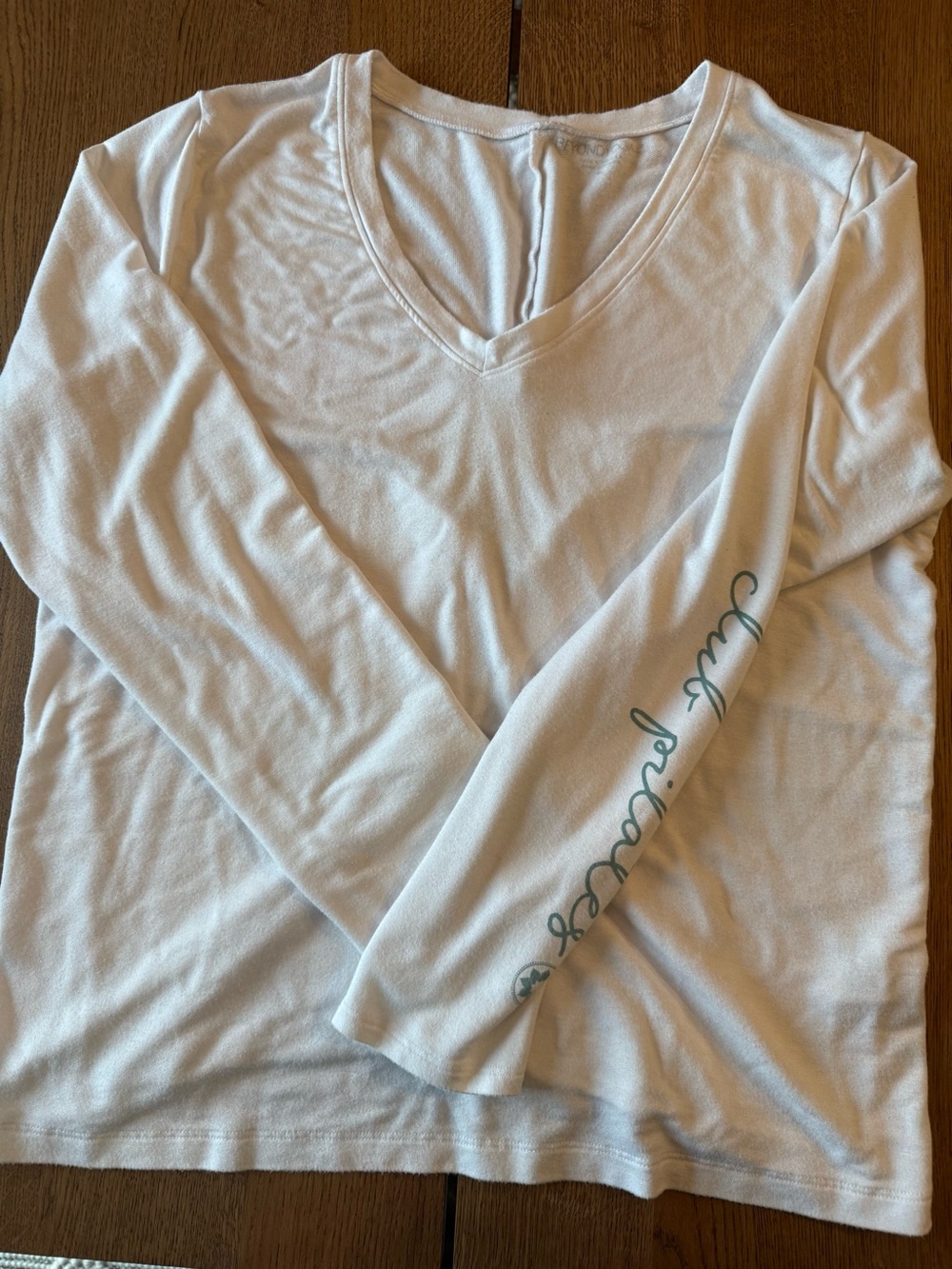 Beyond Yoga White Long Sleeve Lace Back Top with Teal Script on Sleeve